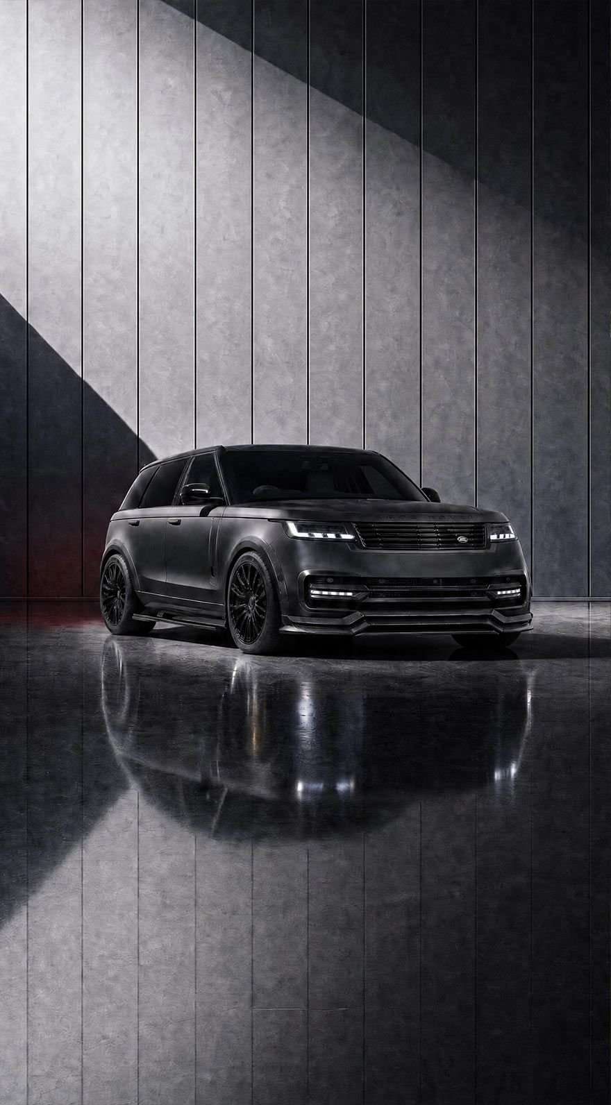 A custom Forge Land Rover Range Rover in matte black is parked on a reflective floor against a textured gray wall.